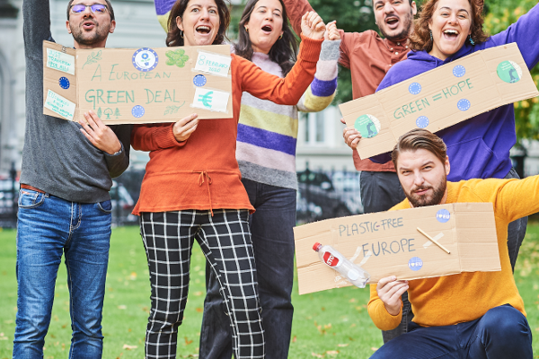 Grupo de pessoas com cartazes «Pacto Ecológico Europeu»